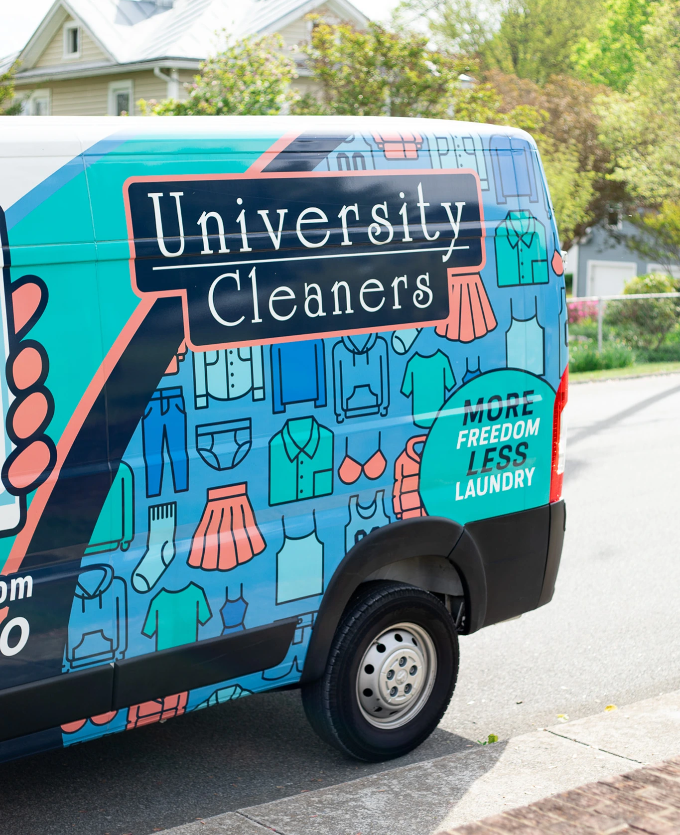 A University Cleaners van is parked on a street. The van is decorated with laundry icons and the slogan 